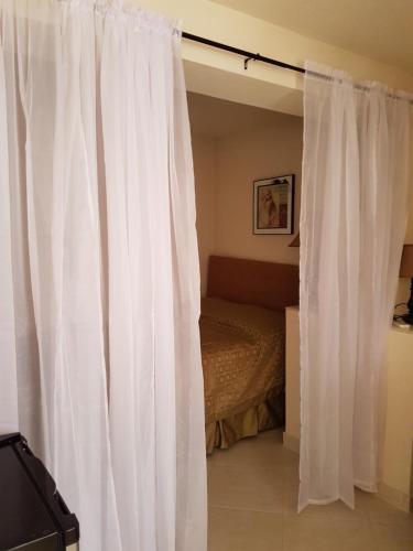 a white curtain in a bedroom with a bed at Glynver Apartments in Christ Church