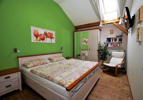 a bedroom with green walls and a large bed at Ferienwohnung Benediktenwand in Lenggries