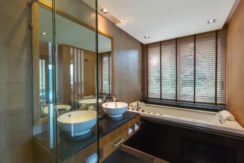 a bathroom with two sinks and a bath tub at Villa Tantawan Resort - Private Pool Villas in Kamala Beach