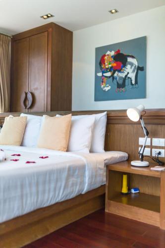a bedroom with a bed and a table with a lamp at Villa Tantawan Resort - Private Pool Villas in Kamala Beach