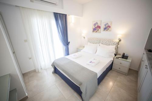 a small bedroom with a bed and a window at Skopelitis Village in Katapola