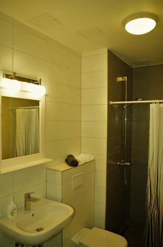 a bathroom with a sink and a toilet and a shower at Modern apartment in Old town in Pärnu