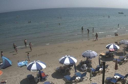 a group of people on a beach with umbrellas at Anetis Hotel in Tsilivi