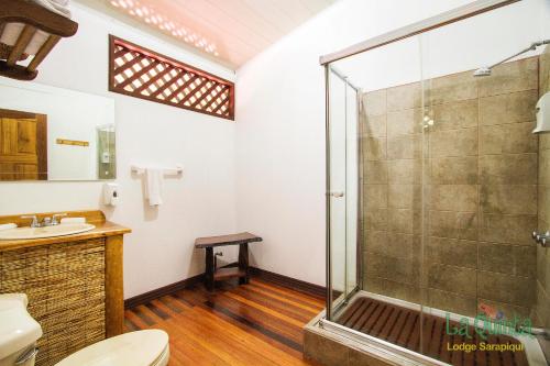 a bathroom with a shower and a toilet at La Quinta Sarapiqui Lodge in Sarapiquí