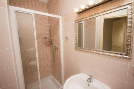a bathroom with a shower and a toilet and a mirror at Guest House Šterk in Nova Gorica