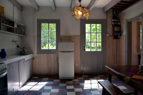 Sainte-Eulalie-en-BornにあるLa Maison Ratabouのキッチン(冷蔵庫、テーブル、窓付)