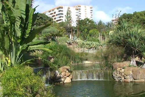 a pool of water with a waterfall in a park at Apartamento Minerva Jupiter. The perfect accommodation for your vacation in Benalmádena