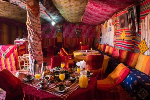 un ristorante con un tavolo e sedie in una stanza di Desert Bivouac Mhamid a M'Hamid
