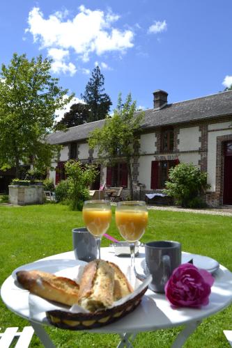- une table avec du pain et deux verres de jus d'orange dans l'établissement La Grenouillere, à Portes