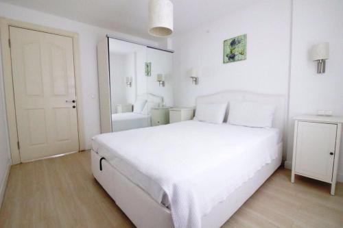 Un dormitorio blanco con una gran cama blanca. en Casita Verdi Evleri, en Yalıkavak