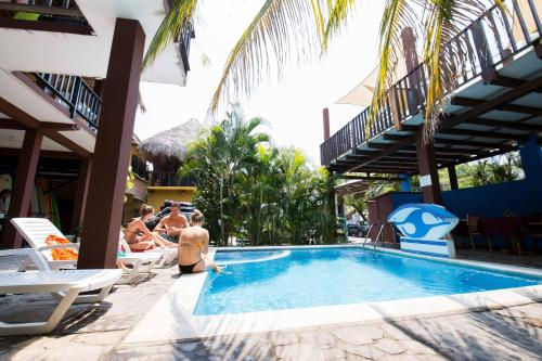 un grupo de personas sentadas alrededor de una piscina en Papaya Lodge, en La Libertad