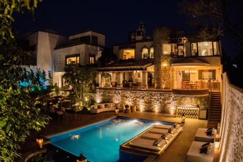 une grande maison avec une piscine la nuit dans l'établissement Maja Hotel Boutique, à Morelia