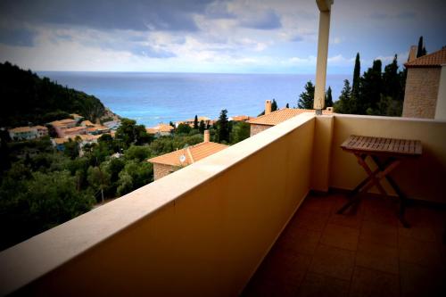 a balcony with a bench and the ocean in the background at Agios Nikitas View in Agios Nikitas