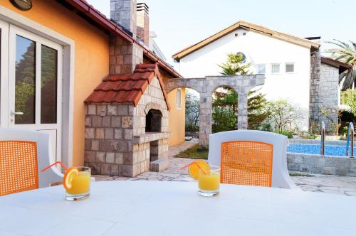 a white table with orange chairs and orange juice at Apart Hotel Apple Cat Montenegro KO Bijela in Bijela