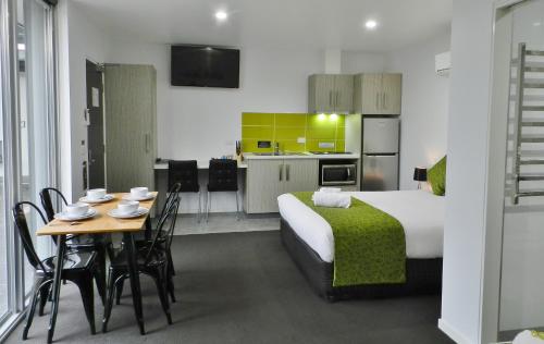 a kitchen with a table, chairs and a refrigerator at Motel 24 in Wodonga