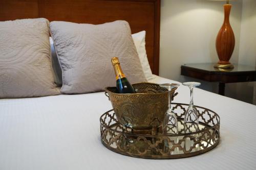 een dienblad met een fles champagne en glazen op een bed bij Hôtel Marie-Rollet in Québec