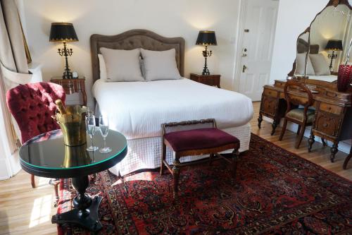 a bedroom with a bed and a table and a piano at Hôtel Marie-Rollet in Quebec City