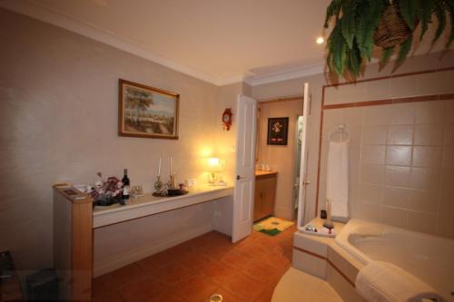 a bathroom with a tub and a sink at Kalimna Spa Room in Blackheath