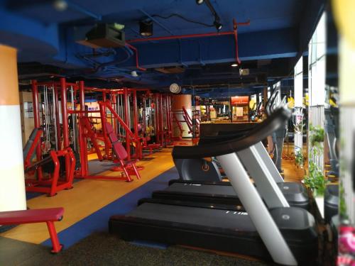 a gym with a treadmill and red chairs at The Legend Nuomo Service Apartment in Guangzhou