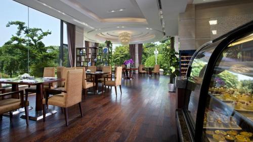 a dining room with tables and chairs in a restaurant at Zhejiang Xizi Hotel in Hangzhou