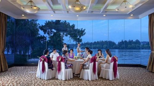 a group of children sitting around a table in a room at Zhejiang Xizi Hotel in Hangzhou
