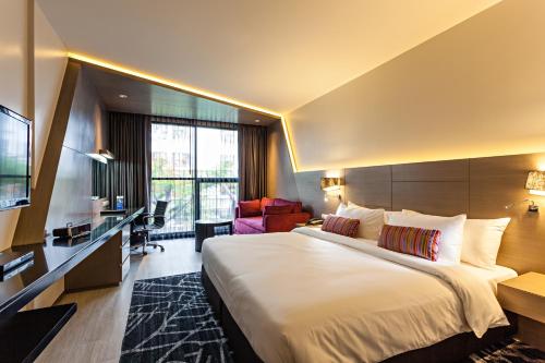 Best Western Plus Sukhumvit 1 في بانكوك: غرفه فندقيه سرير كبير وتلفزيون