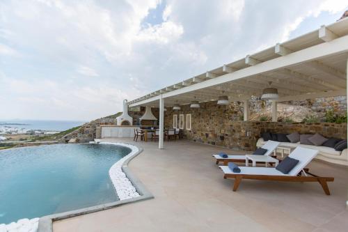 a villa with a swimming pool and a patio at Naxos Rock Villas in Stelida