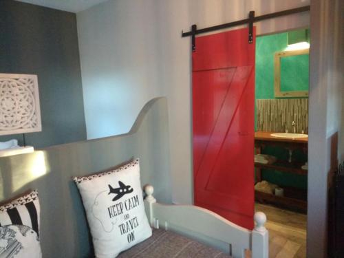 a room with a red door and a pillow at La Pausa Lodge de Campo in Duggan