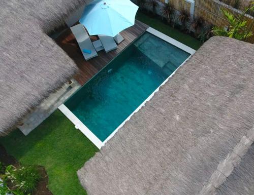 an overhead view of a swimming pool with an umbrella at Villa Saia in Gili Islands