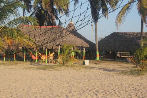 a resort on the beach with palm trees at El Remanso del Santuario in Camarones