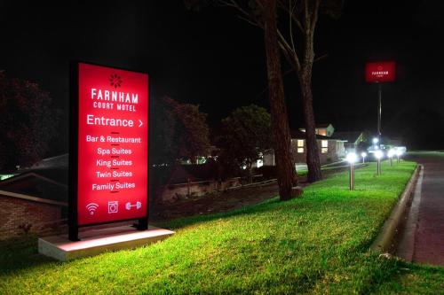 a sign on the side of a street at night at Farnham Court Motel and Restaurant in Morwell