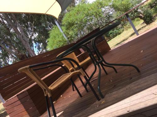 a bench on a wooden deck under an umbrella at The Rocks Apartments in Halls Gap