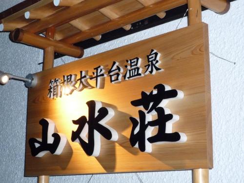 a wooden sign with japanese writing on it at Sansuisou in Hakone