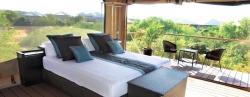 a bedroom with a white bed on a balcony at Eco Beach Wilderness Retreat in Broome