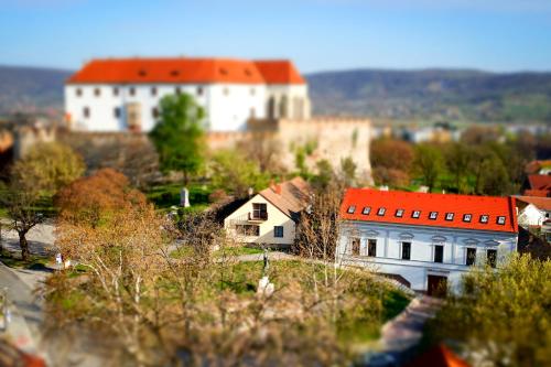 a large white building with a red roof on a hill at Brigadéros Vendégház in Siklós