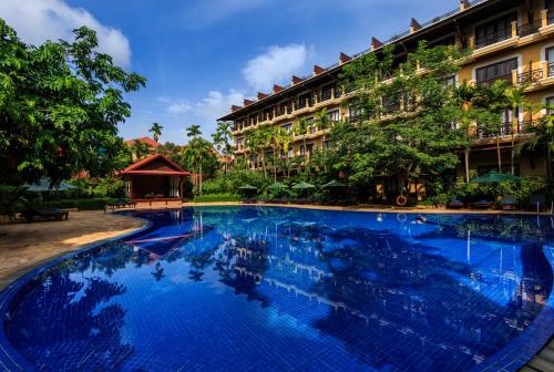 a large blue swimming pool in front of a building at Angkor Paradise Hotel in Siem Reap