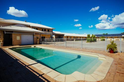 una piscina frente a una casa en Club Motor Inn, en Narrabri