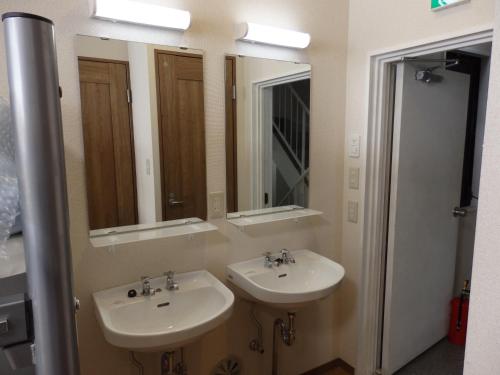 ein Badezimmer mit zwei Waschbecken und zwei Spiegeln in der Unterkunft Backpacker's Mini House in Tokio