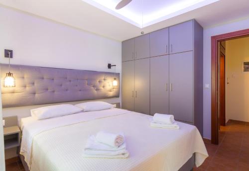 a bedroom with a white bed with towels on it at Ntinas Filoxenia Hotel & Spa in Skala Potamias