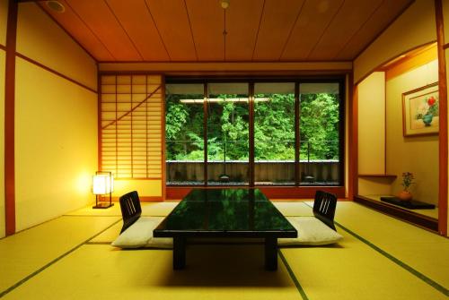 a dining room with a table and a window at Shoenso Hozugawatei in Kameoka