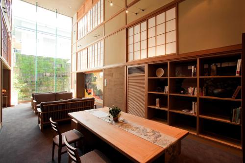a large room with a wooden table and chairs at Shoenso Hozugawatei in Kameoka