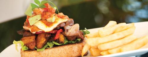 a sandwich and french fries on a white plate at Eco Beach Wilderness Retreat in Broome
