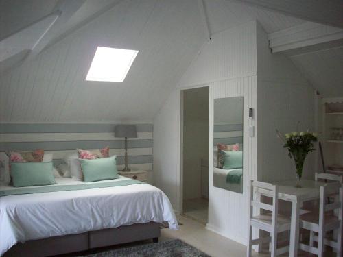 1 dormitorio con 1 cama y tragaluz en Guest House Ascot Place, en Port Elizabeth