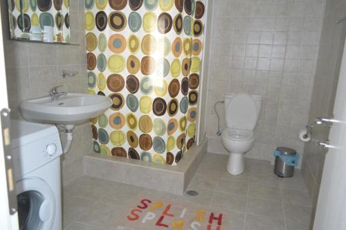 a bathroom with a sink and a toilet and a shower curtain at Anthi City Center Apartment in Rhodes Town