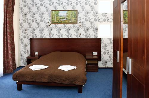 a bedroom with a bed with two towels on it at City Club European in Chernivtsi