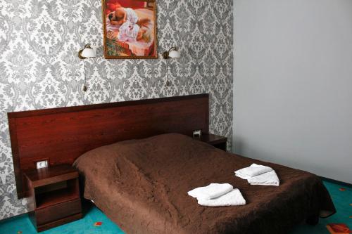 a bedroom with a bed with two towels on it at City Club European in Chernivtsi