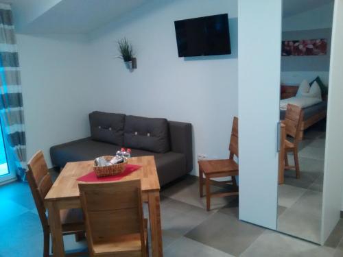 a living room with a couch and a table at Gästehaus Brunnerhof - Eitting in Eitting