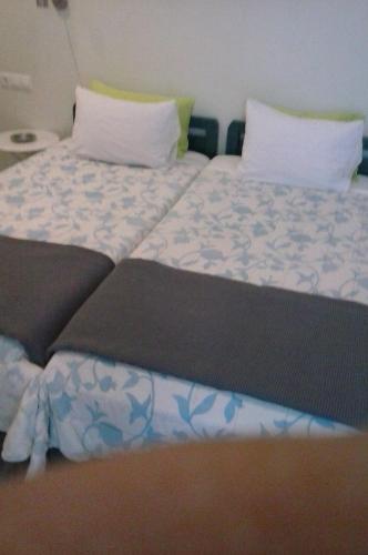 a bedroom with a bed with blue and white sheets at Windmill Naxos in Naxos Chora