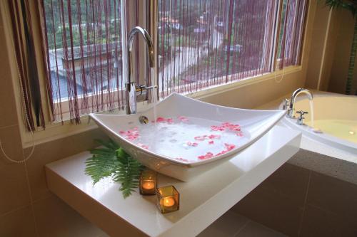 La salle de bains est pourvue d'un lavabo et de fleurs. dans l'établissement Cha Guo Zi, à Datong