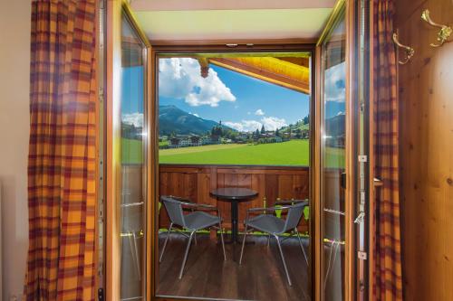 a view from the balcony of a house with a table and chairs at Pension Ederhof in Jochberg